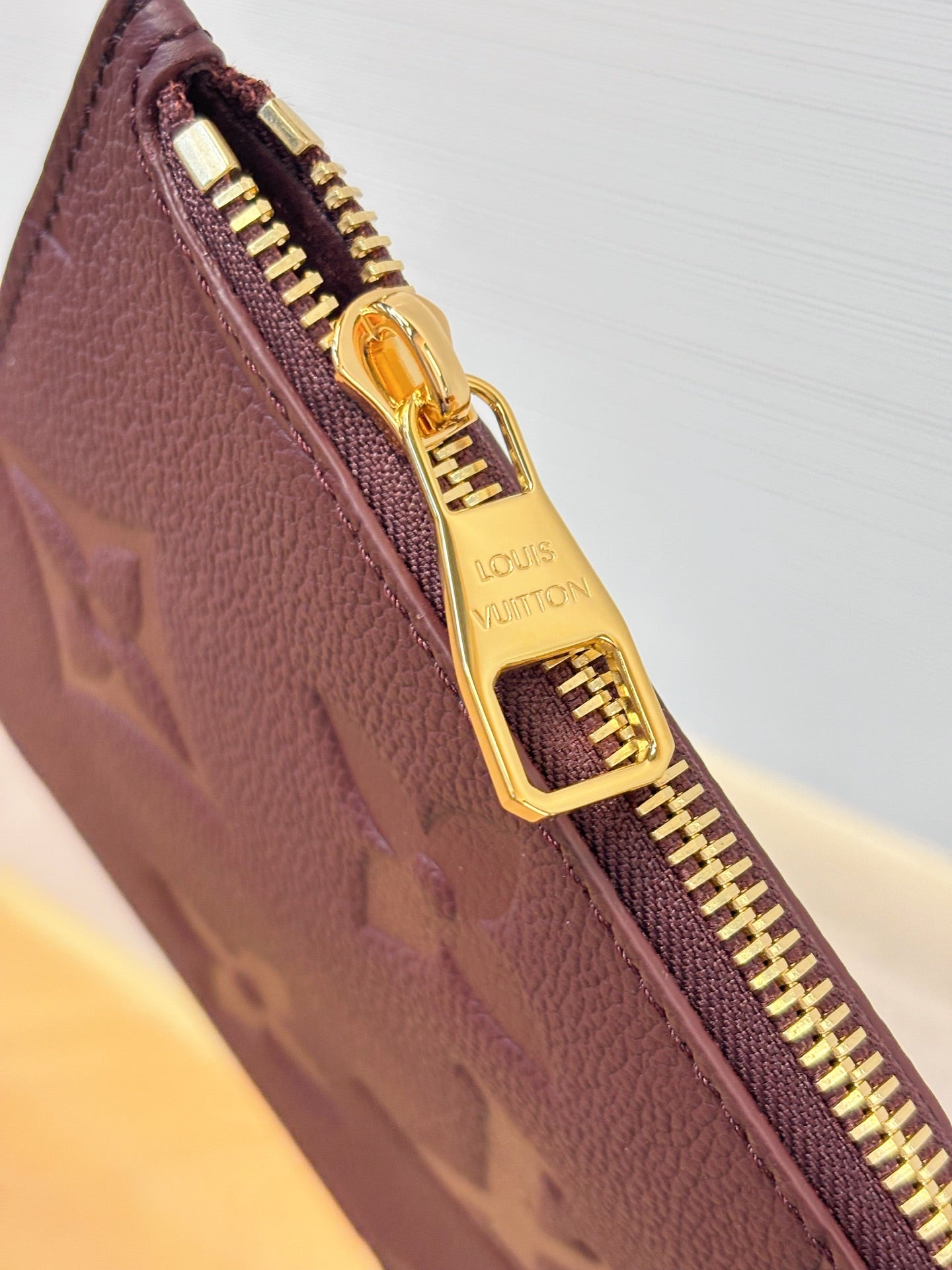 Louis Vuitton monogram bag zipper detail in dark plum with gold-tone zipper pull