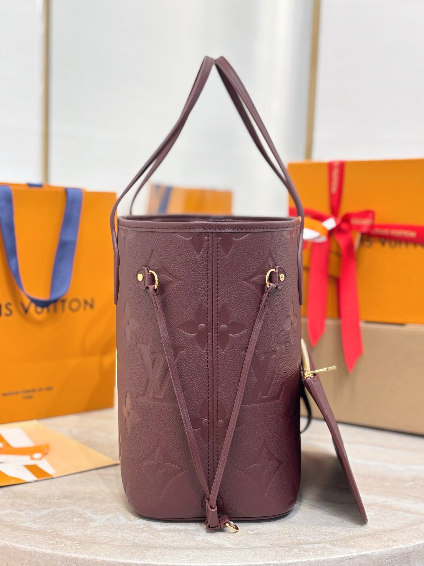 Louis Vuitton monogram bucket bag in dark plum with shoulder strap and gold buckles