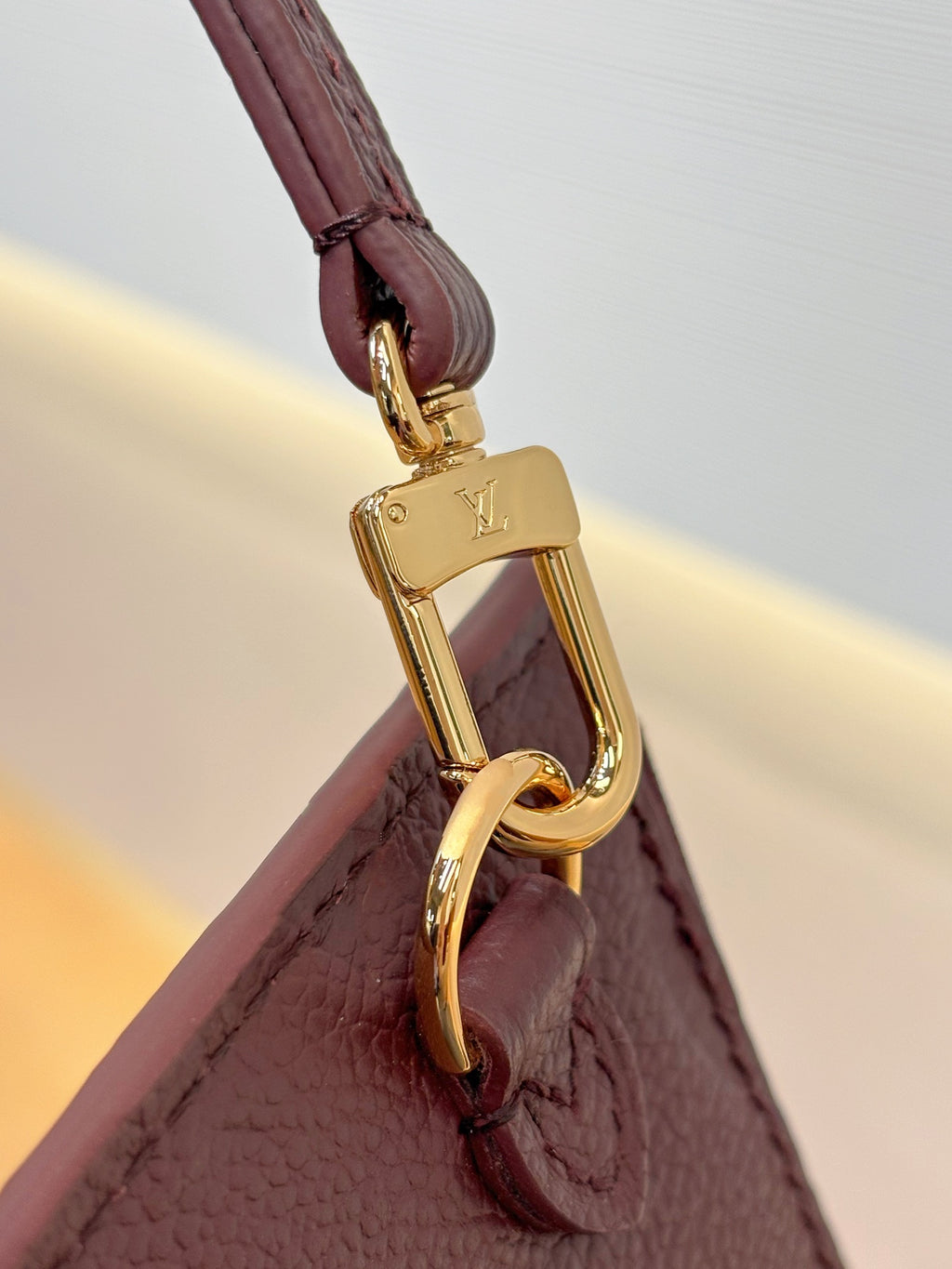 Louis Vuitton bag strap attachment with gold carabiner clasp, dark plum leather