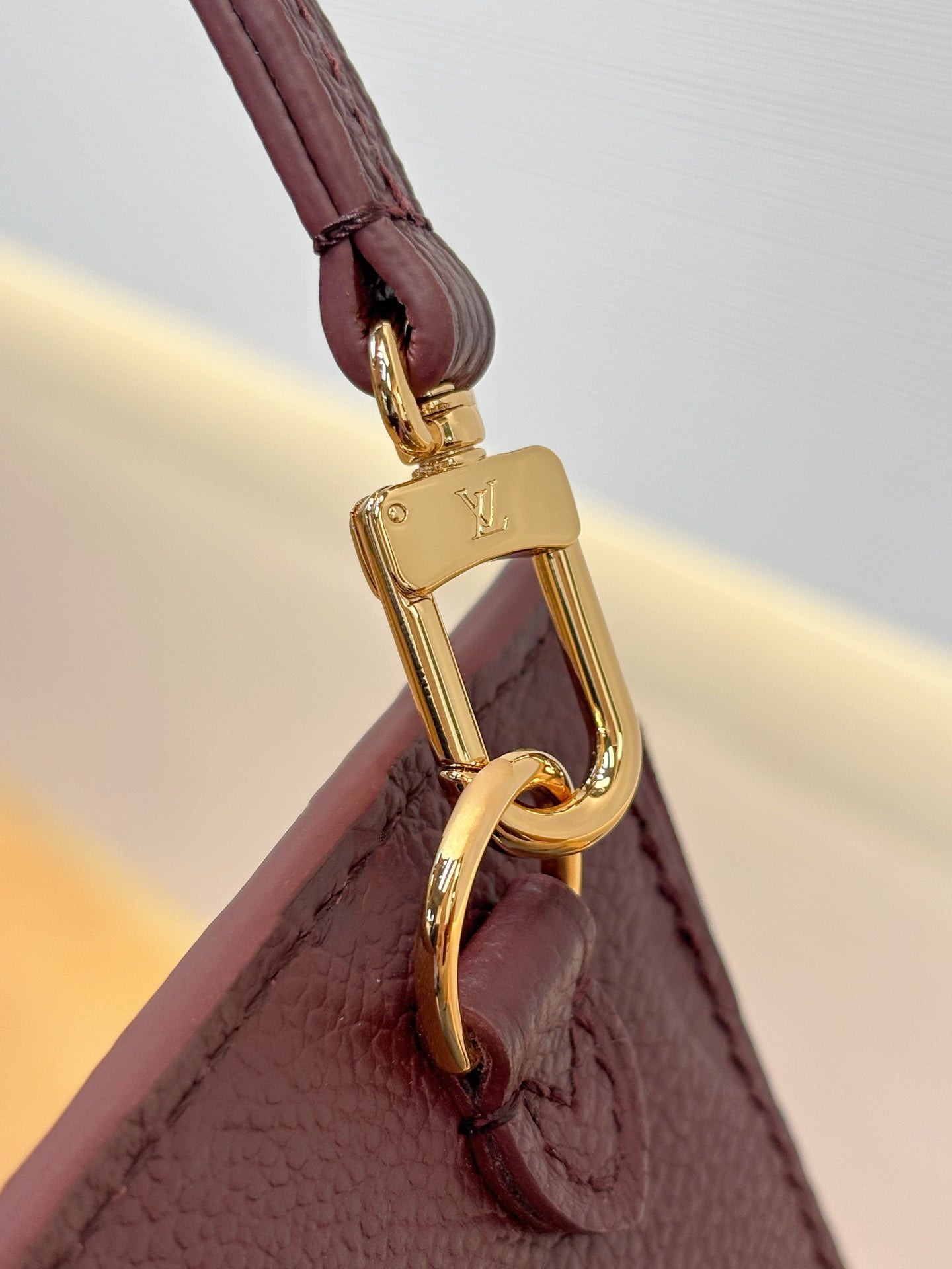 Louis Vuitton bag strap attachment with gold carabiner clasp, dark plum leather