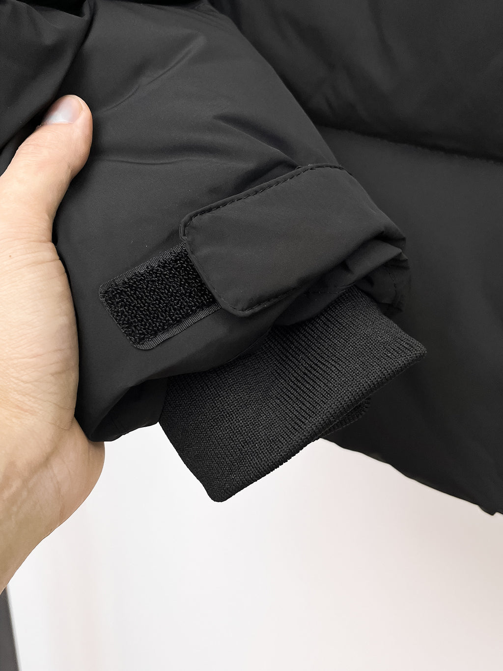 Puffer jacket cuff with knit ribbed lining and snap strap detail