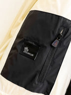 Puffer jacket pocket with zipper and Moncler label, black side