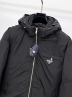 Close-up of black hooded puffer jacket with front zipper and triangular logo badge