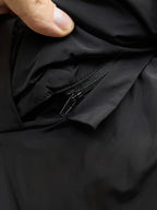 Black puffer jacket fabric with close-up of zipper and zipper pull tab