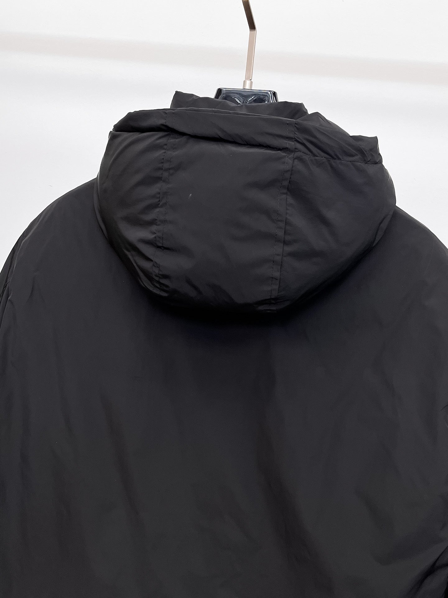 Long black puffer jacket hood with stitched seam and top edge detail