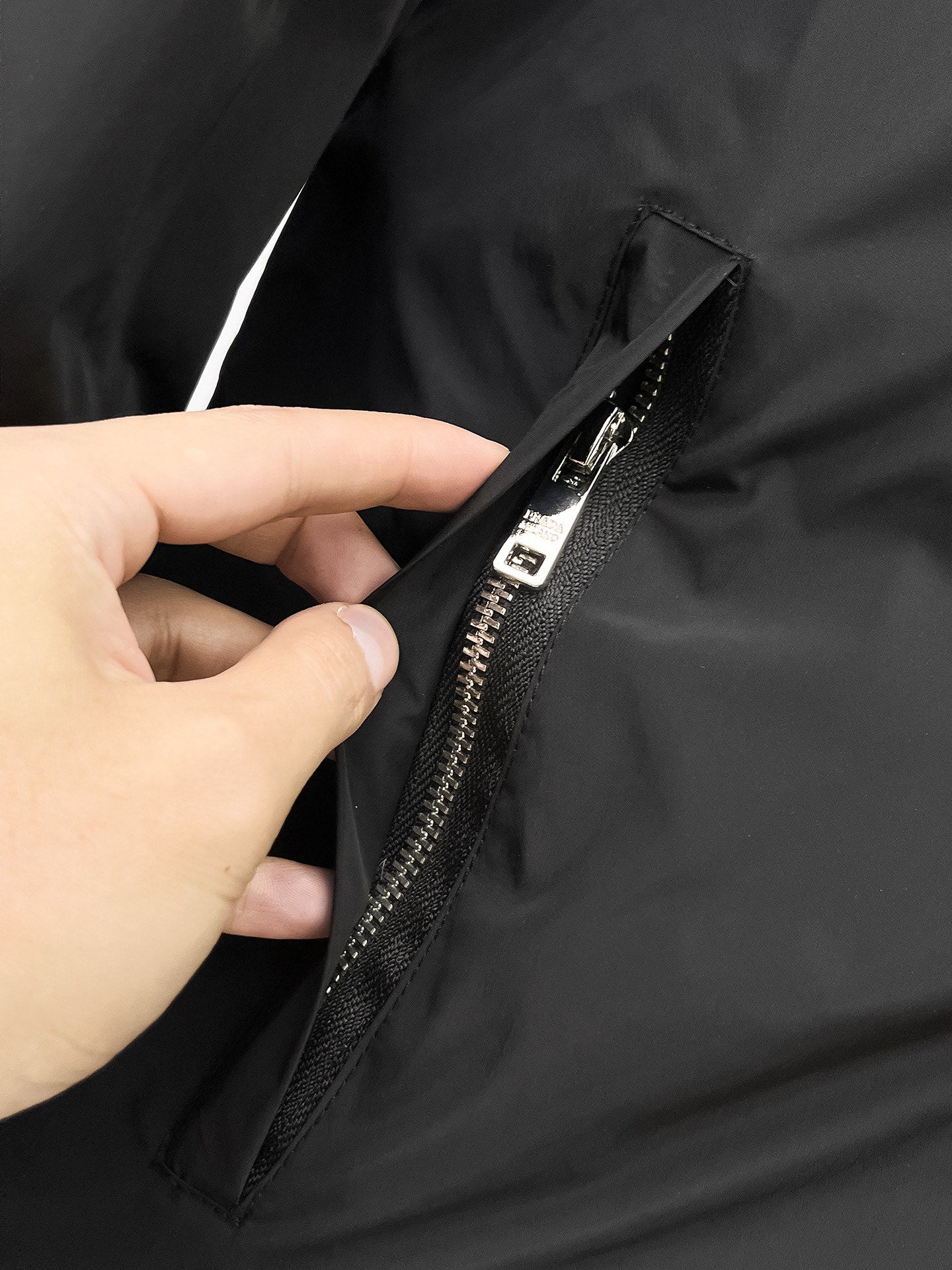 Prada long coat zipper detail with black fabric and metal pull