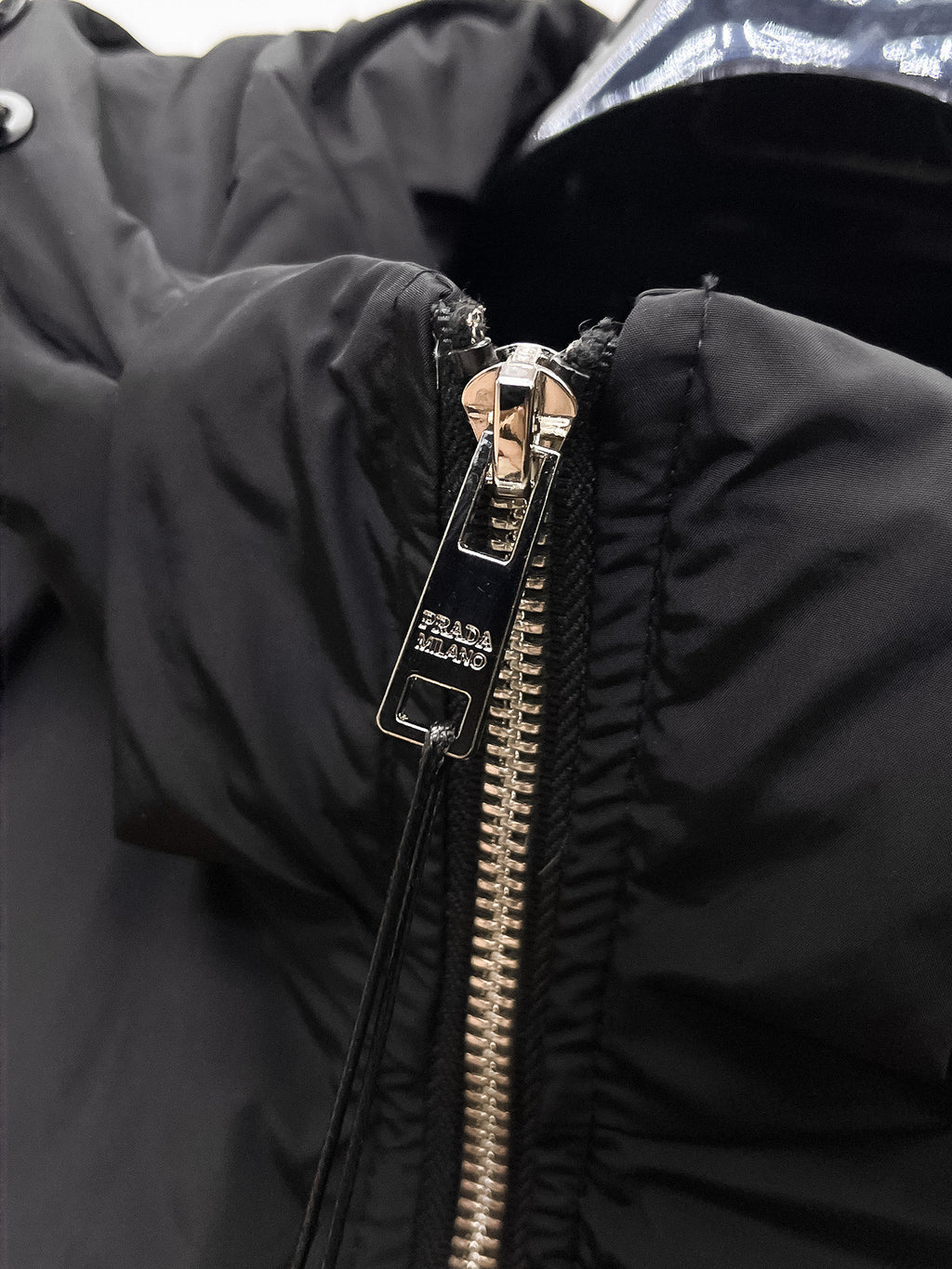 Close-up of black front zipper hardware on puffer jacket