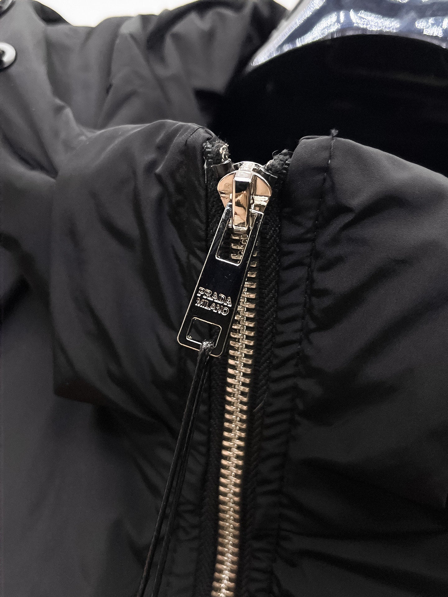 Close-up of black front zipper hardware on puffer jacket