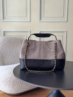 Two-tone Chanel handbag on display with gold-tone chain strap and quilted dark navy bottom
