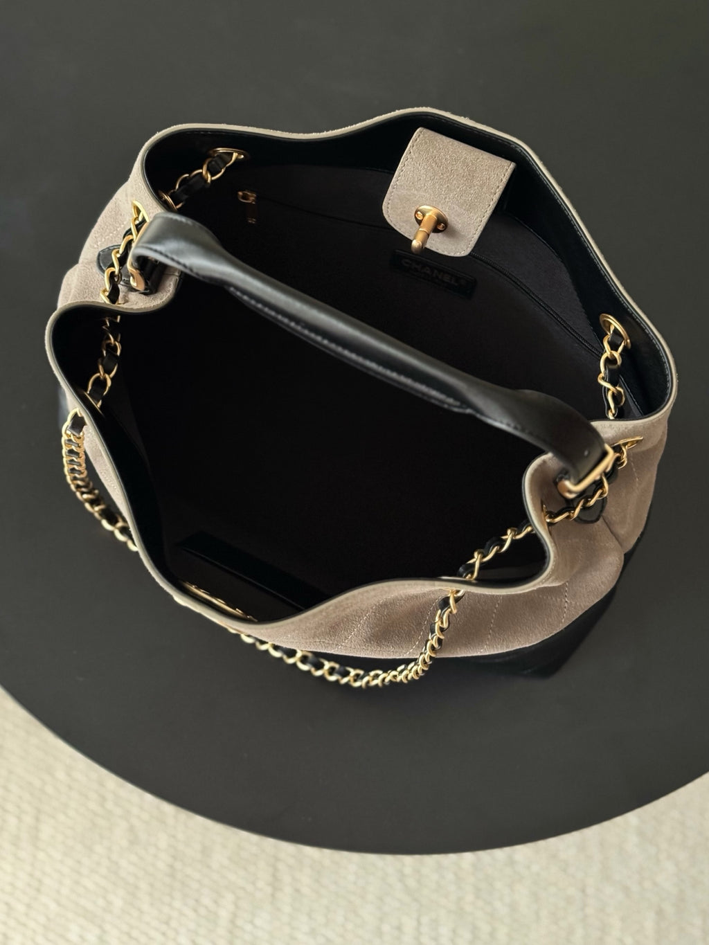Two-tone Chanel handbag open view with gold-tone chain strap, top handle, and clasp