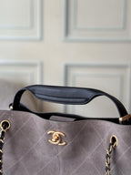 Two-tone Chanel handbag front close-up with logo, gold-tone hardware, and top handle