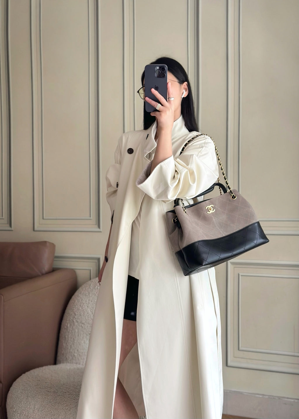 Woman holding a two-tone Chanel handbag with gold-tone chain strap and quilted front