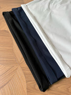 Folded polo shirts in black, navy, and white