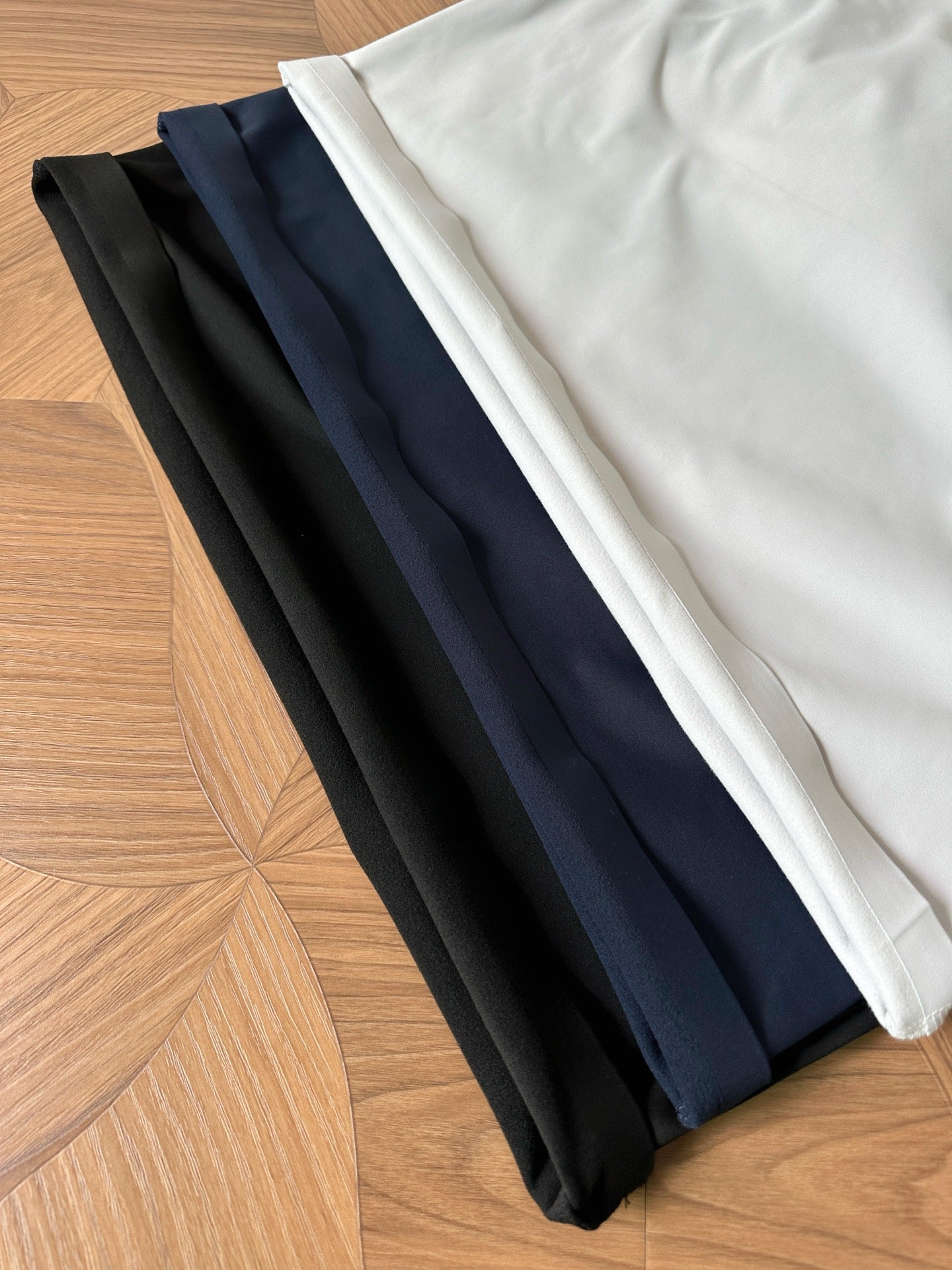 Folded polo shirts in black, navy, and white