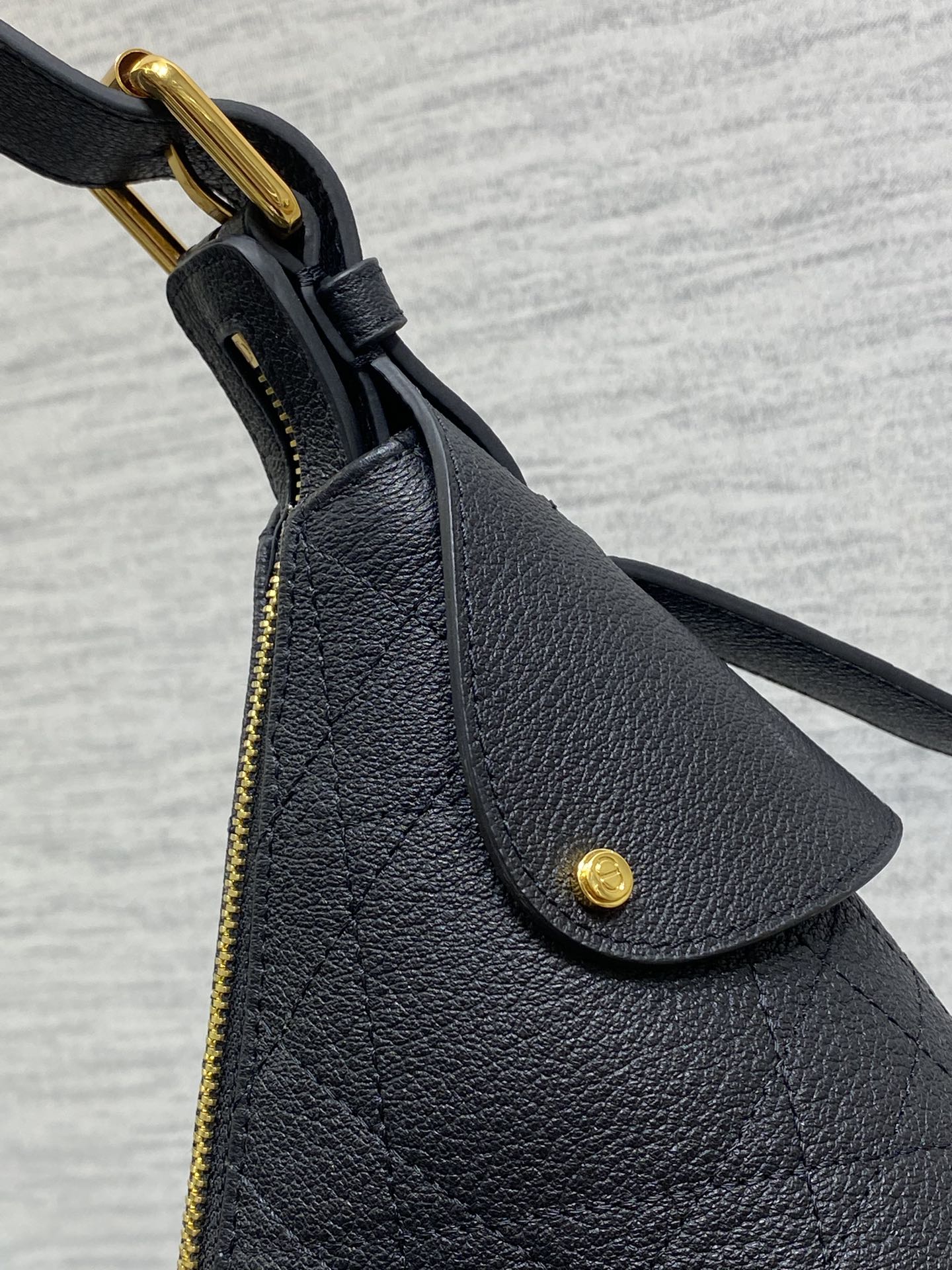 Dior black leather bag corner with curved flap and gold-tone ring handle