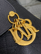 Dior logo charm in gold tone on textured black leather
