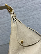 Dior handbag side with light beige textured leather flap and gold-tone button