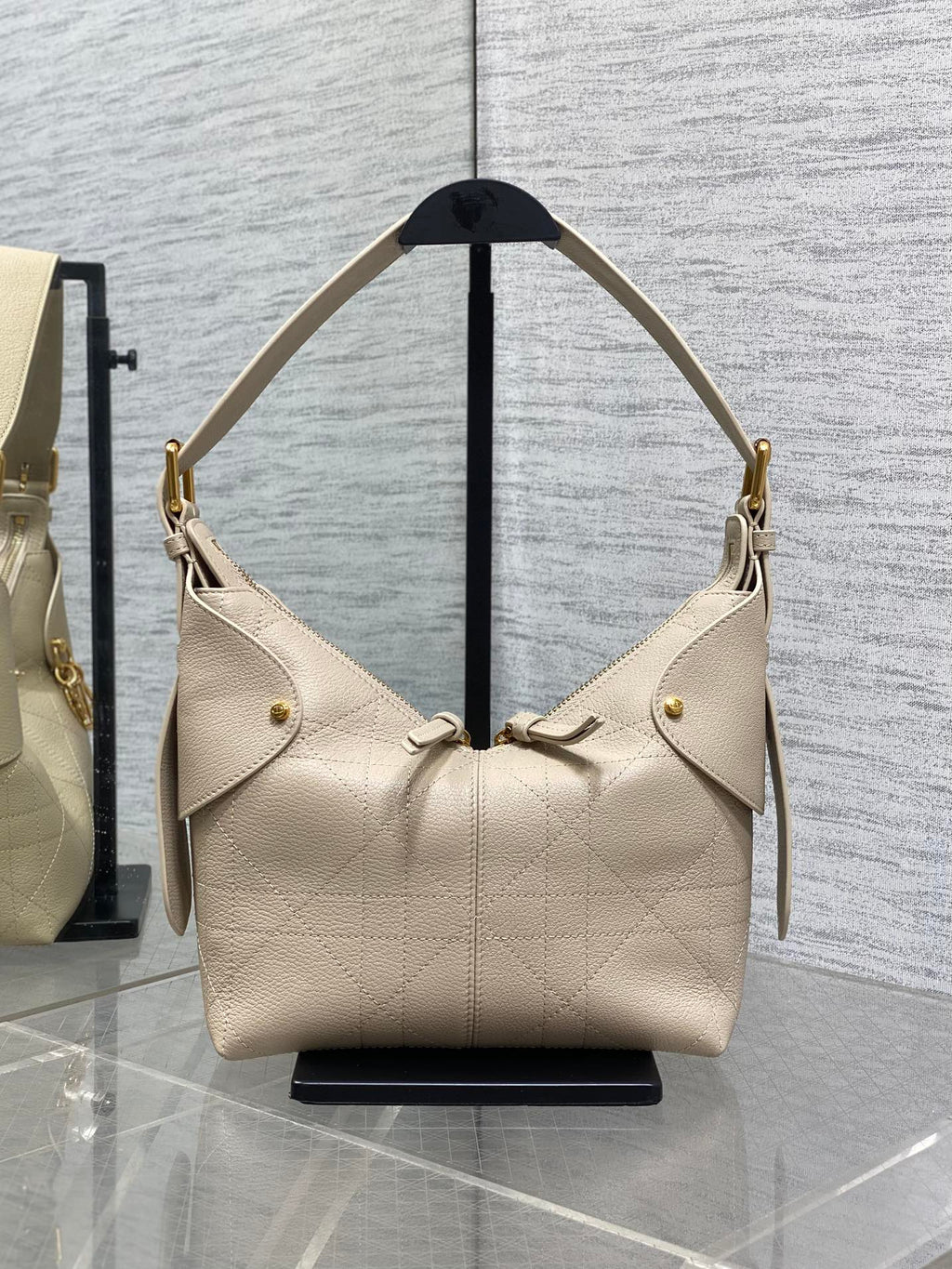 Dior handbag in light beige textured leather with gold hardware and shoulder straps