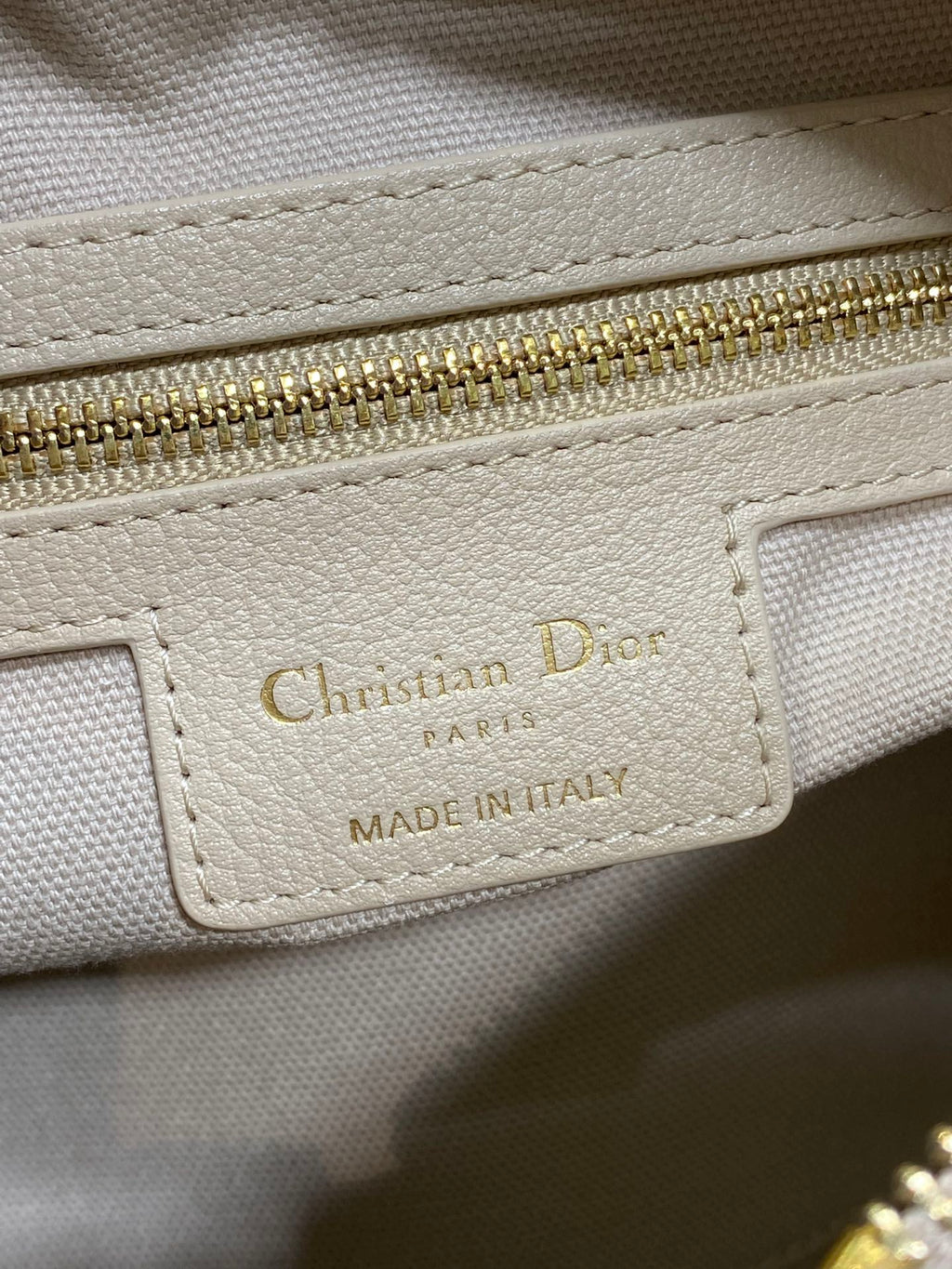 Dior brand label on light beige leather: Christian Dior Paris, made in Italy