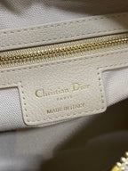 Dior brand label on light beige leather: Christian Dior Paris, made in Italy