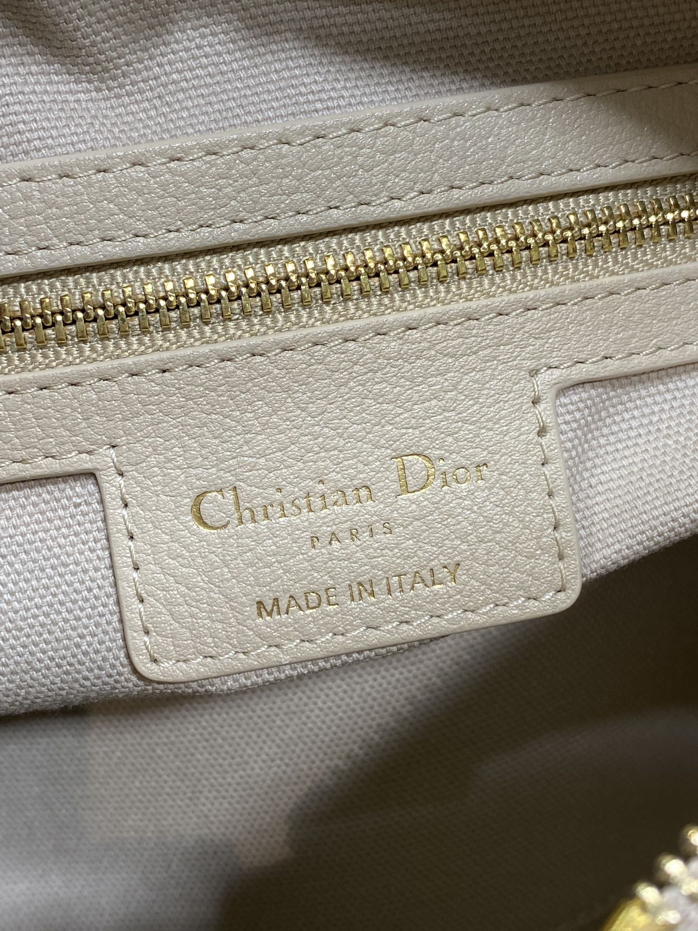 Dior brand label on light beige leather: Christian Dior Paris, made in Italy