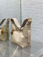 Dior handbag with light beige textured leather, gold hardware, and adjustable strap