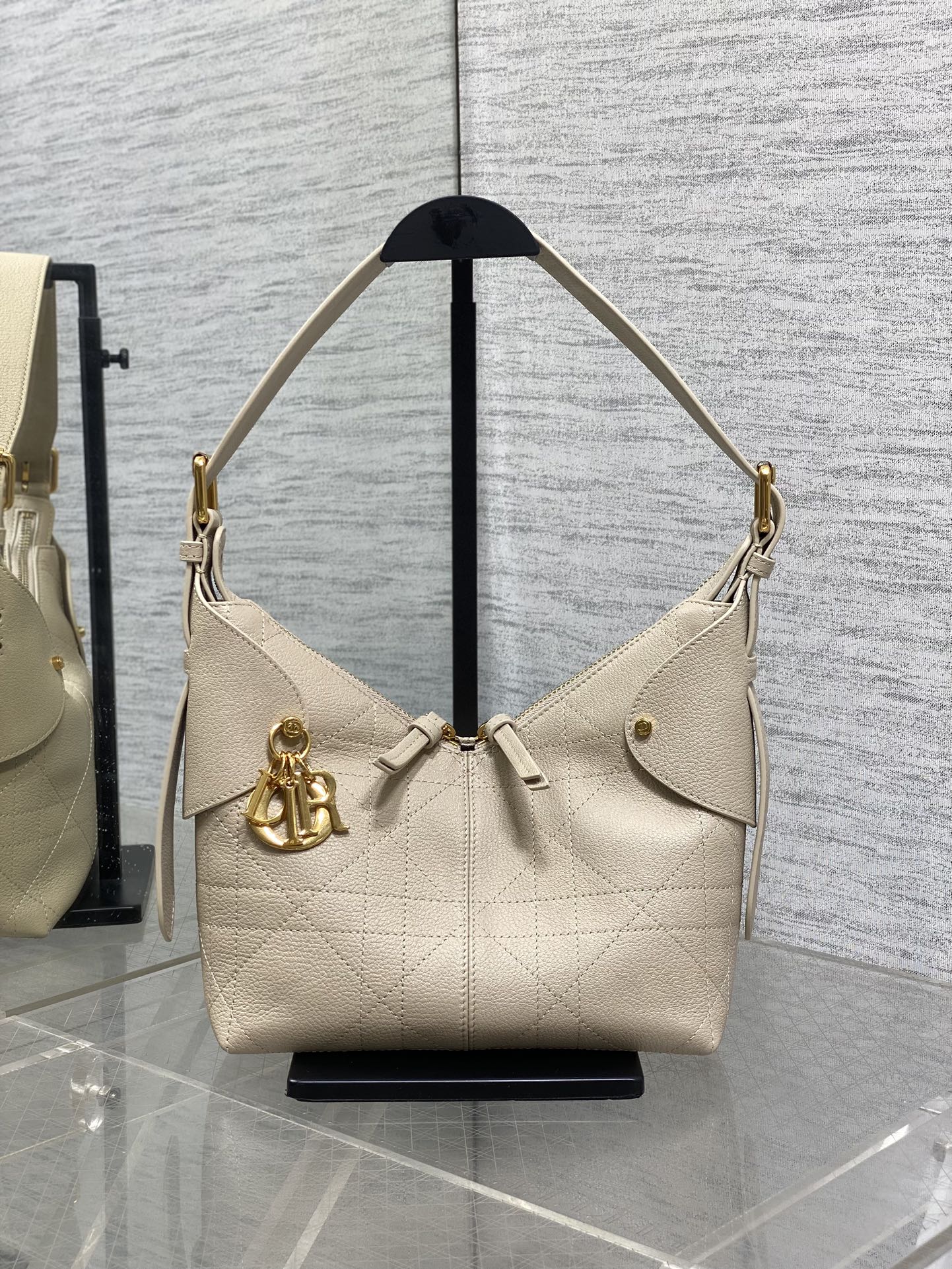 Dior handbag in light beige textured leather with gold hardware and shoulder straps