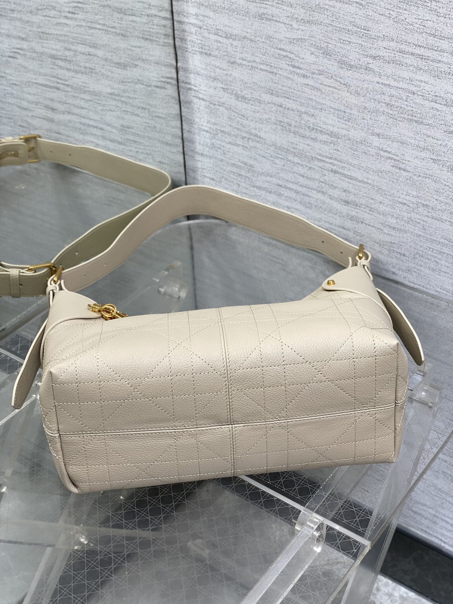 Cream quilted bag with wide shoulder strap and curved top handles
