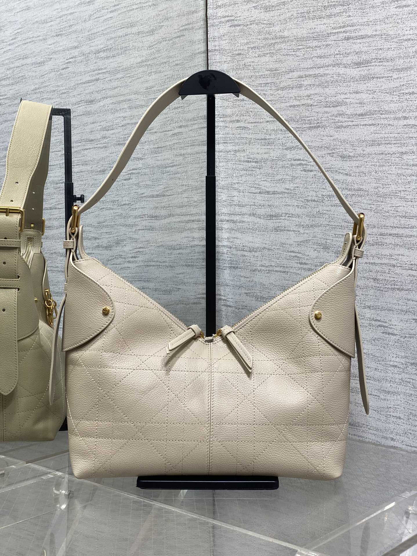 Cream quilted leather shoulder bag with adjustable straps and gold hardware
