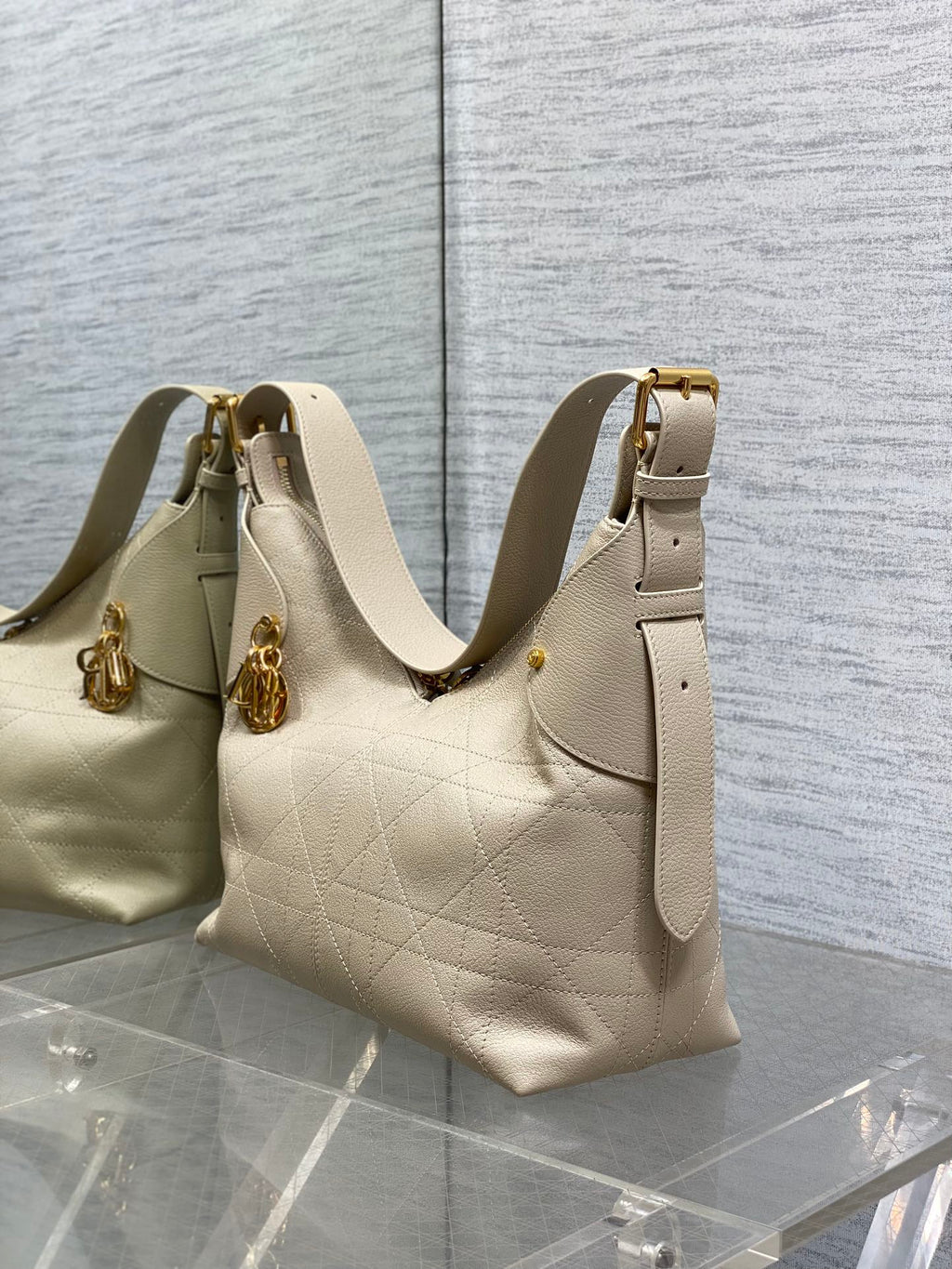 Cream quilted shoulder bag with gold top handles and side tab pocket