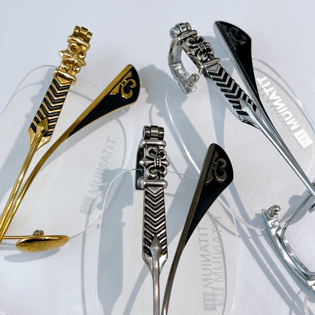 Eyeglass hinges and temple details in gold, silver, and black with patterned finish