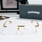 Gold-rimmed eyeglasses with clear lenses and patterned gold temples with dark accents