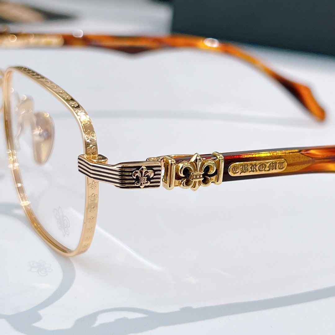 Gold eyeglasses frame close-up with ornate temple hinge detail.