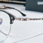 Close-up of silver eyeglasses hinge and bridge with patterned temple arms