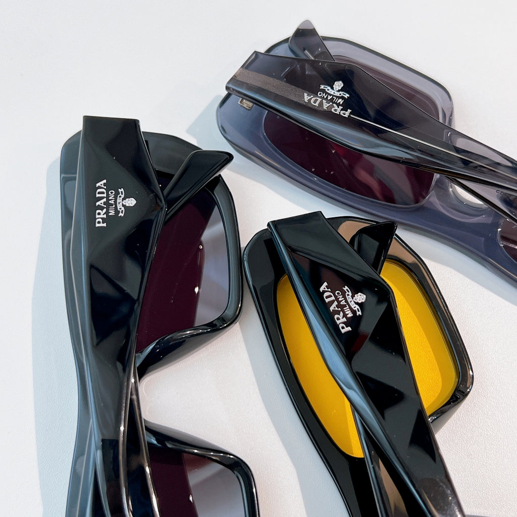Prada sunglasses with assorted frames and tinted lenses, stacked
