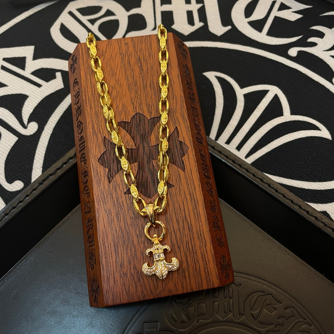 Gold cross pendant necklace displayed on wooden box