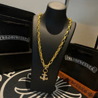 Gold chain necklace with cross pendant, hanging on mannequin bust