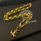 Gold chain necklace with cross pendant charms on black box