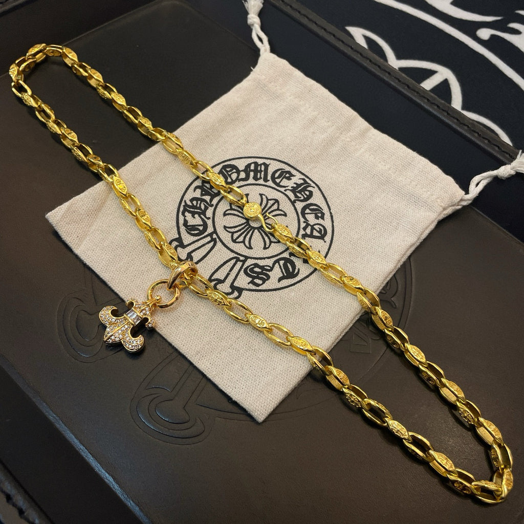 Gold chain necklace with cross pendant laid on drawstring pouch