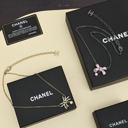 Necklace set with silver and gold chains, bow charms, and pearl accents in gift boxes