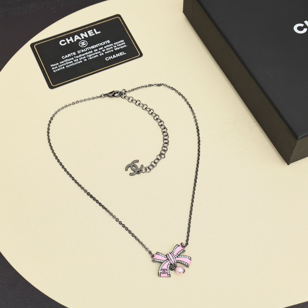 Silver necklace with pink bow pendant and pearl, plus small logo charm