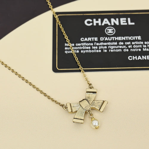 Chanel necklace with gold chain and small pearl charm with ribbon bows