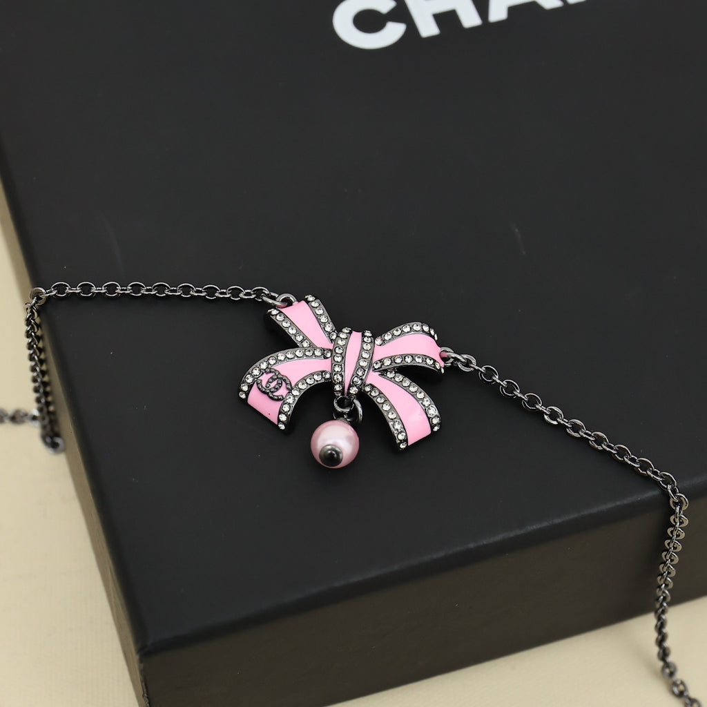 Silver necklace with pink ribbon bow charm and small pearl drop
