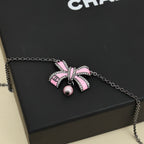 Silver necklace with pink ribbon bow charm and small pearl drop