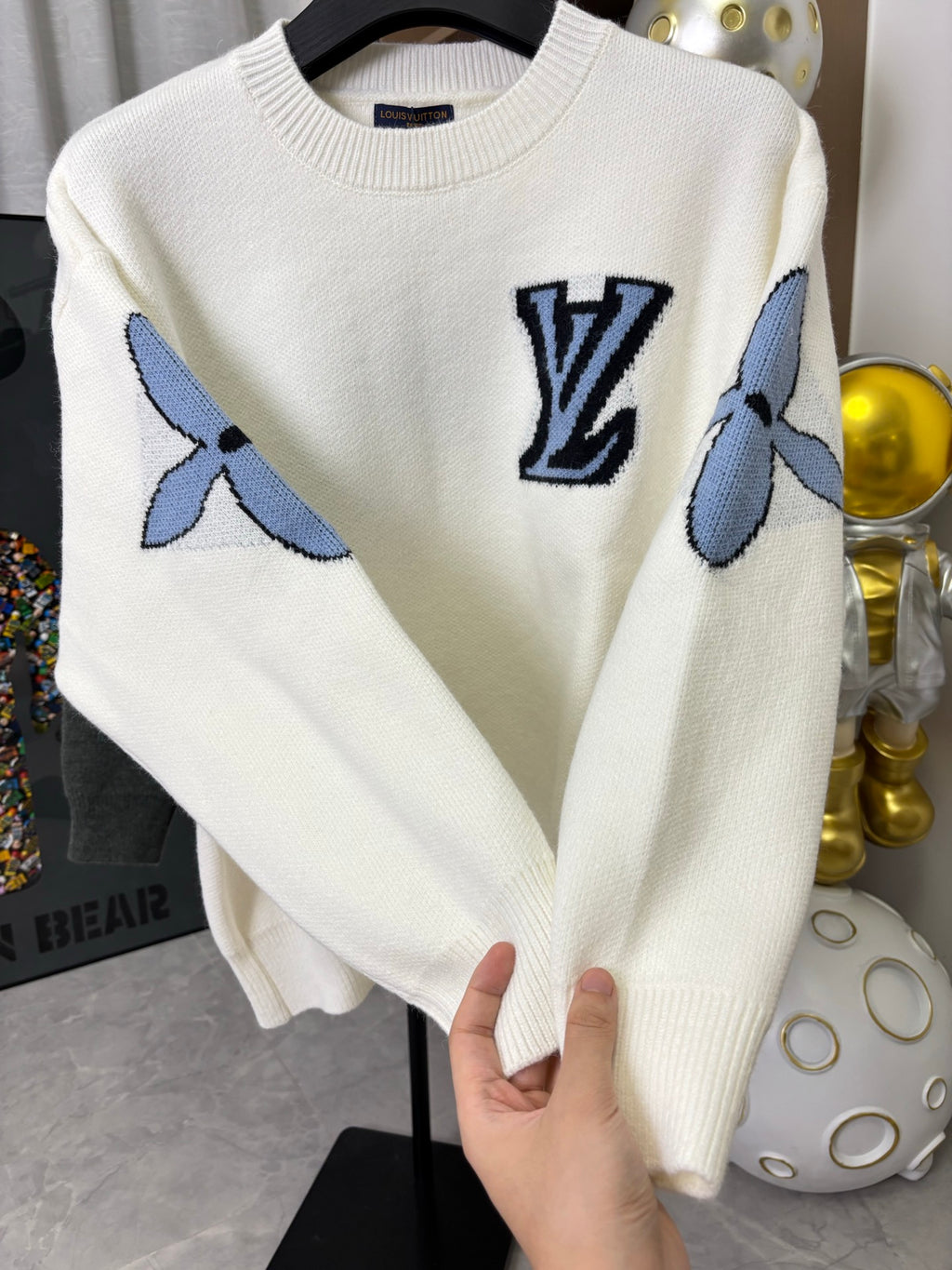 Off-white knit sweater with navy LV logo and blue sleeve graphic