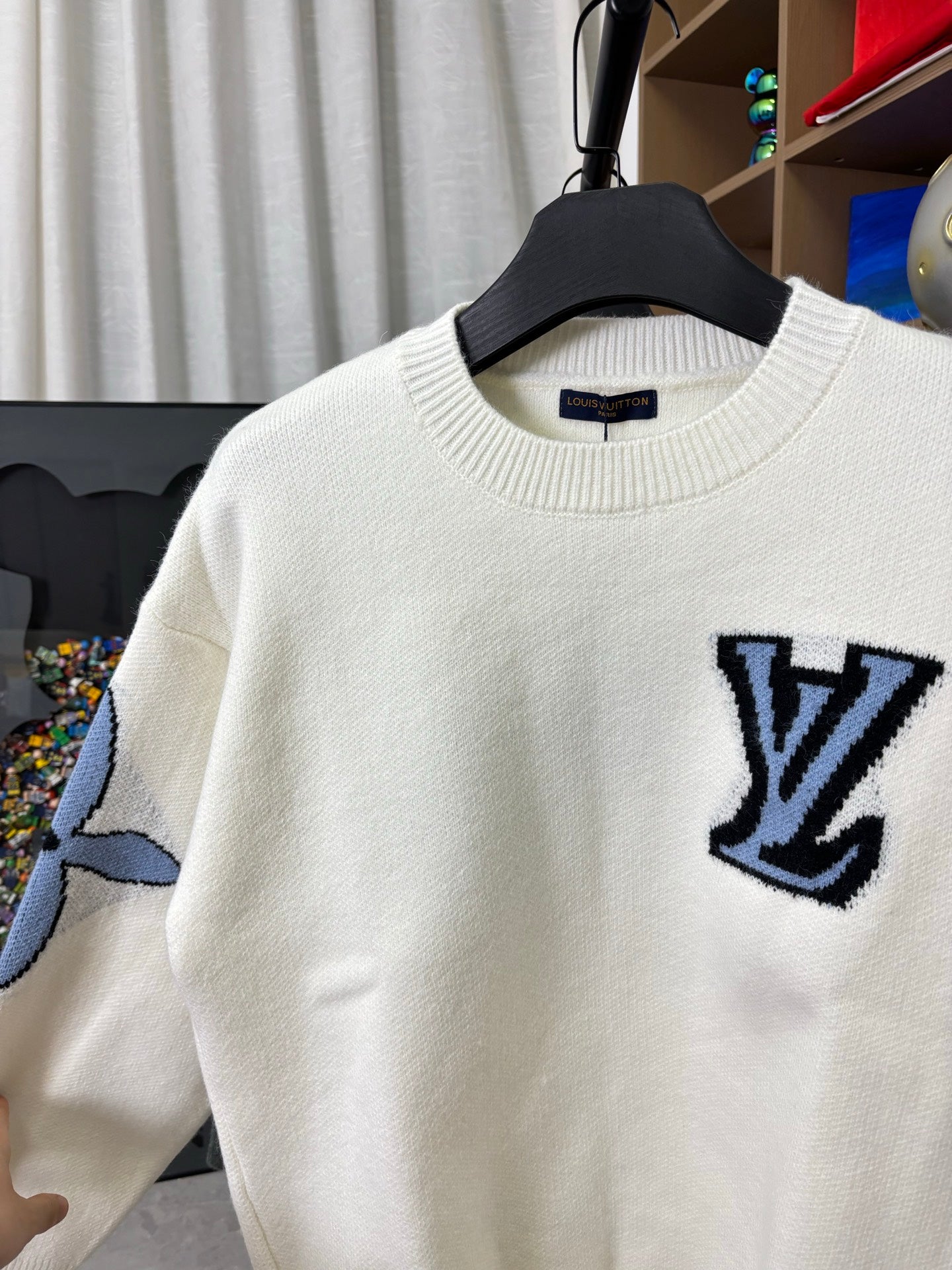Off-white knit sweater detail with navy LV logo on chest