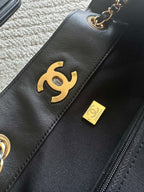 Chanel CC logo patch and small leather tag on black quilted bag