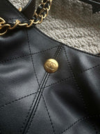 Chanel logo snap button on quilted leather bucket bag front panel