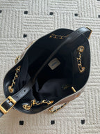 Open black bag interior with light lining, chain strap, and gold hardware