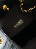 Inside view of black handbag with CHANEL fabric label on interior zip pocket.